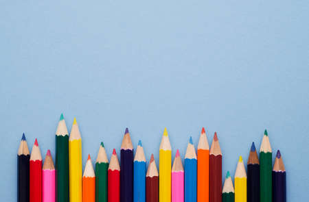 Colorful crayons organized in a row over blue background, above view with copy space for text or other designの写真素材