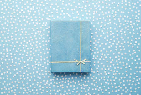 Christmas Gift Box with snow confetti over blue background, above viewの写真素材