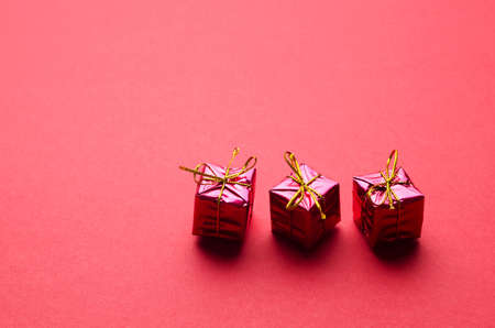 Small Red Christmas Gift Boxes over red background with space for text or other desings