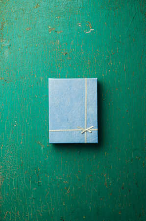 Christmas present box over grunge green wooden table, above viewの写真素材