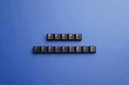 Merry Christmas text made of keyboard keys over dark blue background, above viewの写真素材