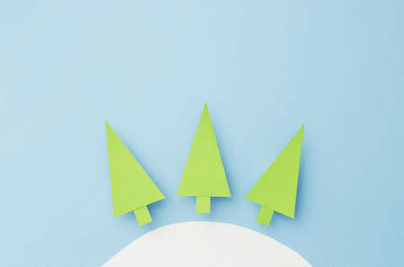 Small Paper Christmas Trees cut from green paper over blue backgroundの写真素材