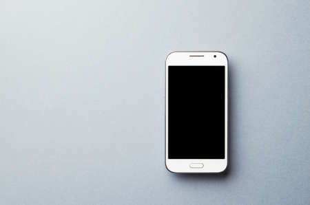 White Smart Phone over dark gray background, top view with copy space for text or other designの写真素材