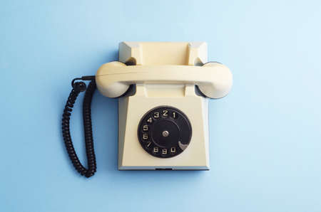 Retro rotary phone over blue background, above viewの写真素材
