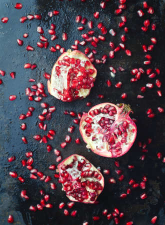 Pomegranates over dark black metallic background, above view