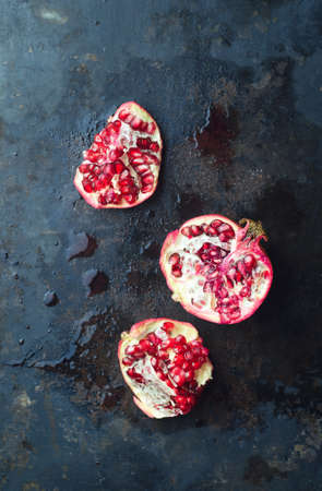 Pomegranates over dark black metallic background, above viewの写真素材