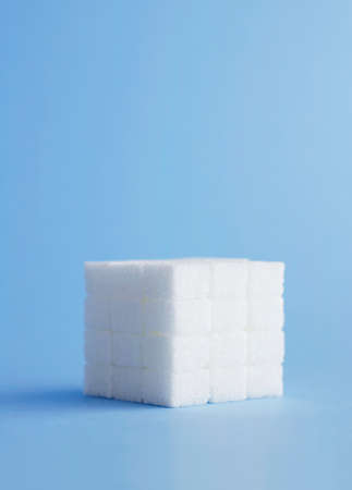 Cube made of sugar cubes over blue backgroundの写真素材