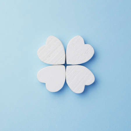 Hearts arranged as clover over blue background, top view