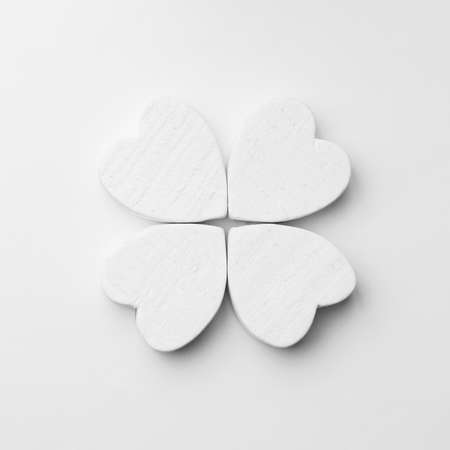 Hearts arranged as clover over white background, top view