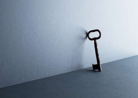 Silhouette of an vintage key leaning against the dark blue background with negative spaceの写真素材