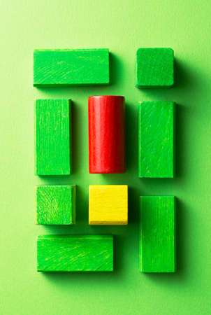 Green and red wooden cubes over green background, top viewの写真素材