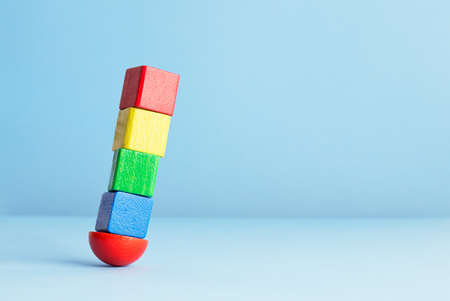 Colorful wooden cubes in balance over blue backgroundの写真素材