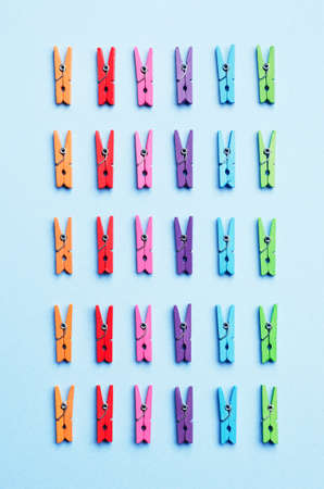 Laundry clips organized over blue background, top view