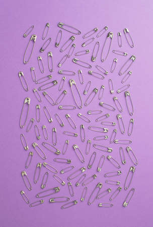 Safety pins over mauve background, top viewの写真素材