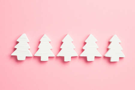 Christmas Trees organized in a row over pink background, top viewの写真素材