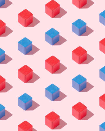 Blue and red wooden cubes organized over pink backgroundの写真素材