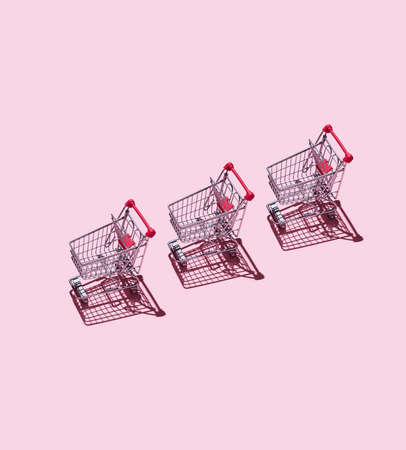 Three Shopping Carts over pink backgroundの写真素材
