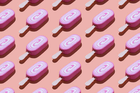 Pink ice cream organized in a row over coral backgroundの写真素材