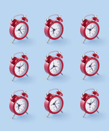 Classic red clock organized in a row over a blue background