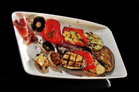 Mushroom appetizer with ham and pepper isolated on blackの写真素材