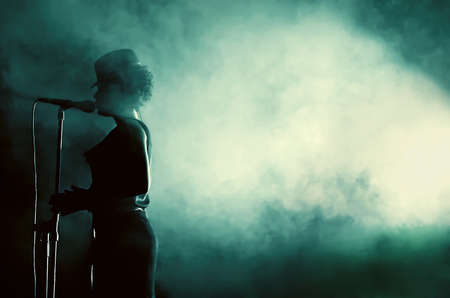 Live performing artist's silhouette while singing at the microphoneの写真素材