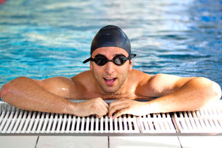 Portrait man finishing swimming training, getting out of poolの写真素材
