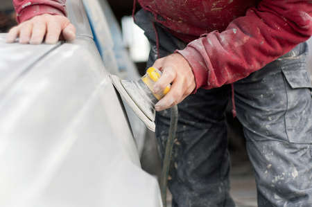 auto mechanic worker polishing the basic layer of car body の写真素材