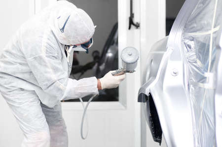 Auto painter spraying paint on a car bodyの写真素材