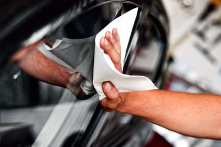 auto car worker and mechanic cleaning a cars window with special tool for scratches and wiper auto car worker and mechanic cleaning a cars window with special tool for scratches and wiper