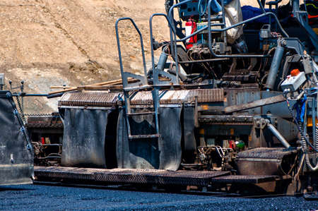 Qualified engineer operating asphalt paver machine during road constructionの写真素材