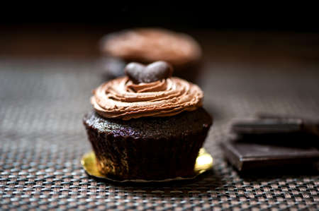Detail of a chocolate muffin with sweet cream on top, fresh out of the ovenの写真素材