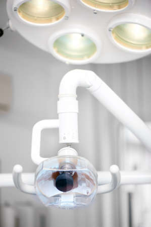 Dentist chair and light stand against tools and equipment background の写真素材