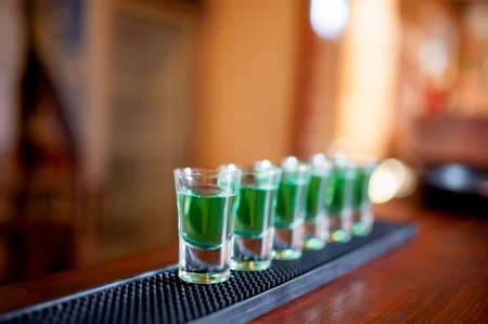 alcoholic shots of different drinks at a party in a nightclub on the counterの写真素材