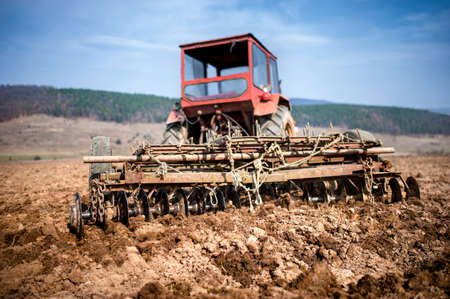 Tractor at farm working and plowing the field  Agriculture and harvestingの写真素材