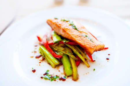 Smoked salmon with fried vegetables as main dish at local restaurantの写真素材