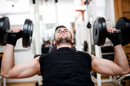 bodybuilder training in the gym  chest - dumbbell bench pressの写真素材
