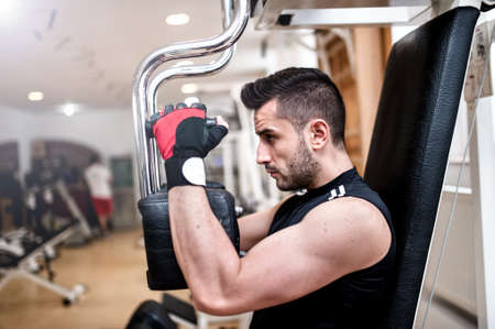 sporty man doing chest exercise at gym, daily workout routineの写真素材