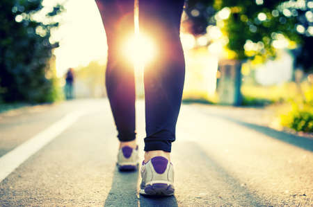 Close-up of woman athlete feet and shoes while running in park  Fitness concept and welfare with female athlete joggin in city park