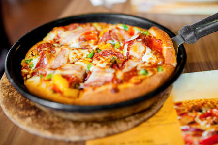 Close-up of hot, italian dinner with pizza and fresh ingredients, served on hot plateの写真素材
