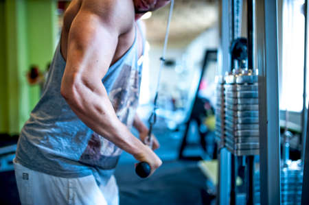 Close-up of triceps of an athletic, muscular and attractive man working out at gymの写真素材