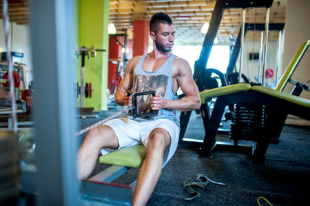 Athletic sexy adult model working out at gym, fitness and healthy lifestyle concept