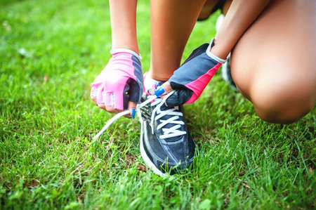 female runner and athlete preparing shoes for joggingの写真素材
