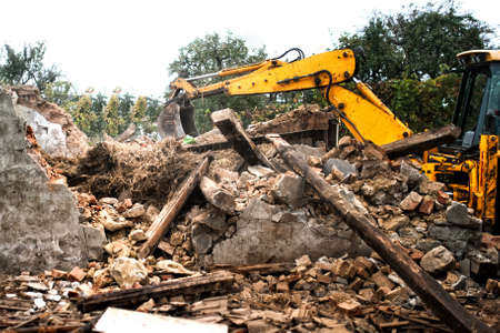 Hydraulic crusher, industrial excavator machinery working on a rainy site demolitionの写真素材