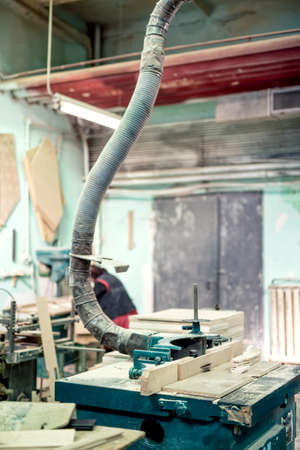 Mitre saw cutting a wooden board at a steel and wood factory. Lathe, drilling and milling tools and objectsの写真素材