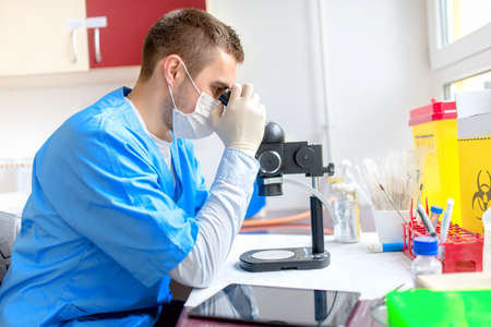 male chemist working with microscope in laboratoryの写真素材