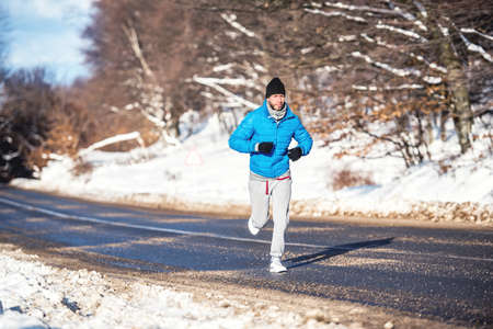 Active man, jogging and running during a sunny winter day. Outdoor working out conceptの写真素材