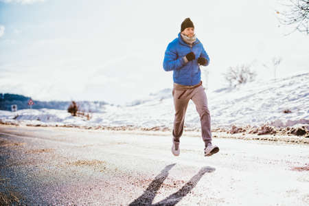 close-up of man running and jogging on a cold winter dayの写真素材