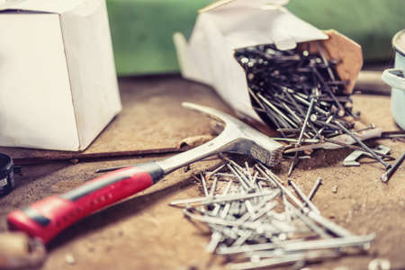 Hammer and nails on construction site, on wooden board. Soft, vintage effectの写真素材