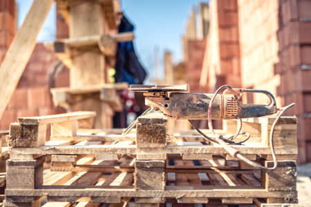 Angle grinder power tool on construction site - tools and wooden blocks at building site