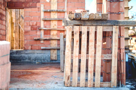 wall building and tools, bricks and wooden blocks on construction siteの写真素材